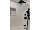 Close up of shower with black fixtures, tiled walls, and built in shower niche at 10744 Drummond Rd, Tampa, FL 33615