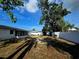 Large backyard with new white fence, patio, and mature trees creating an inviting outdoor space at 11735 86Th Ave, Seminole, FL 33772