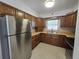 Clean kitchen with wooden cabinets, stainless steel refrigerator, and efficient counter space at 11735 86Th Ave, Seminole, FL 33772