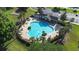 Aerial view of a community pool with palm trees, lounge chairs, and nearby parking at 12136 Luftburrow Ln, Hudson, FL 34669