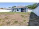 View of the backyard with grass, some weeds, and a fenced perimeter at 12136 Luftburrow Ln, Hudson, FL 34669