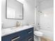 Updated bathroom featuring a navy vanity with gold hardware, a marble countertop, and a shower/tub combo at 12136 Luftburrow Ln, Hudson, FL 34669