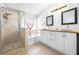 Bright bathroom featuring a glass enclosed shower, soaking tub, and dual sinks with modern cabinetry at 12136 Luftburrow Ln, Hudson, FL 34669