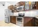 Contemporary kitchen showcasing stainless steel appliances, dark wood cabinetry with glass fronts, and granite countertops at 12136 Luftburrow Ln, Hudson, FL 34669