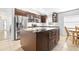 Modern kitchen with stainless steel appliances and dark wood cabinets and island with marble countertop at 12136 Luftburrow Ln, Hudson, FL 34669