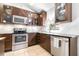 Contemporary kitchen with stainless steel appliances, dark wood cabinets, subway tile backsplash, and granite countertops at 12136 Luftburrow Ln, Hudson, FL 34669
