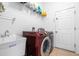 Functional laundry room with modern washer, dryer, utility sink and tile flooring at 12136 Luftburrow Ln, Hudson, FL 34669