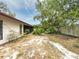 Exterior side view of the house featuring lush backyard and patio area at 1228 Rainbrook Cir, Valrico, FL 33596