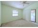 This bedroom features a ceiling fan, light green walls and a sliding glass door at 1228 Rainbrook Cir, Valrico, FL 33596