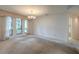 Inviting living room featuring large windows, neutral decor, and an elegant chandelier at 1228 Rainbrook Cir, Valrico, FL 33596