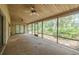 This porch has two ceiling fans and screened windows with views of lush landscaping at 1228 Rainbrook Cir, Valrico, FL 33596