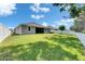 Well-maintained backyard features a spacious lawn and a white fence under a bright blue sky at 12957 Satin Lily Dr, Riverview, FL 33579