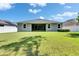 Spacious backyard with lush green lawn, sliding glass doors, and a well-maintained fence at 12957 Satin Lily Dr, Riverview, FL 33579