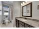 Bathroom with granite countertop vanity, framed mirror, and a shower-tub combo with a curtain at 12957 Satin Lily Dr, Riverview, FL 33579