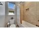 Bright bathroom features a shower-tub combo with light tile and large window for natural light at 12957 Satin Lily Dr, Riverview, FL 33579