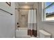 Well-lit bathroom features shower-tub with tiled walls, niche, and neutral two-tone curtain at 12957 Satin Lily Dr, Riverview, FL 33579