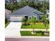 Charming single-story home with a two-car garage, well-manicured lawn, and palm trees at 12957 Satin Lily Dr, Riverview, FL 33579