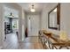 Bright entryway featuring wood-look floors, stylish console table, and views into the living spaces at 12957 Satin Lily Dr, Riverview, FL 33579