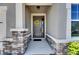 Welcoming front entry with stone accents and a decorative wreath adorning the gray front door at 12957 Satin Lily Dr, Riverview, FL 33579
