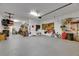 Spacious garage with overhead storage, organized shelving, tools, and room for vehicles at 12957 Satin Lily Dr, Riverview, FL 33579