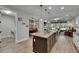 Open-concept kitchen with an island, view of the dining area, living room, and laundry room, with granite countertops at 12957 Satin Lily Dr, Riverview, FL 33579
