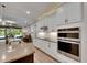 Modern kitchen featuring white cabinets, stainless steel appliances, granite countertops, and a view to the living area at 12957 Satin Lily Dr, Riverview, FL 33579