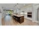 Modern kitchen with white cabinets, island with seating, and open layout to the living room at 12957 Satin Lily Dr, Riverview, FL 33579