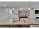 Granite kitchen island with stainless sink and faucet and pendant lighting over looking dining area at 12957 Satin Lily Dr, Riverview, FL 33579
