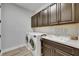 Well-lit laundry room features washer, dryer, sink, and cabinetry for storage at 12957 Satin Lily Dr, Riverview, FL 33579