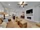 Open-concept living room featuring a modern fireplace, ceiling fan, and seamless flow to the kitchen at 12957 Satin Lily Dr, Riverview, FL 33579