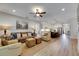 Open-concept living room flows into the kitchen with modern furnishings, hardwood flooring, and neutral tones at 12957 Satin Lily Dr, Riverview, FL 33579