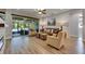 Bright living room with wood floors, neutral color scheme, and view of the lanai through sliding glass doors at 12957 Satin Lily Dr, Riverview, FL 33579
