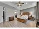 Bright main bedroom features tray ceiling, and wood-look floors with ensuite bath at 12957 Satin Lily Dr, Riverview, FL 33579