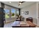 Home office featuring bright windows, wood desk, comfortable armchair, and neutral decor for a professional feel at 12957 Satin Lily Dr, Riverview, FL 33579