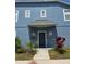 Two-story townhouse featuring a blue exterior with a covered entrance and manicured landscaping at 13157 Kings Crossing Dr, Gibsonton, FL 33534