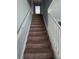 View of carpeted stairway with white railings leading to the upper level of the home at 13157 Kings Crossing Dr, Gibsonton, FL 33534