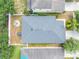 Aerial view of the home highlighting its roof, backyard with seating, screened-in porch and surrounding landscaping at 13803 Chalk Hill Pl, Riverview, FL 33579
