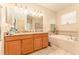 Bathroom with double vanity, granite countertops, and separate tub at 13803 Chalk Hill Pl, Riverview, FL 33579