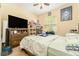 Cozy bedroom featuring a ceiling fan, window, dresser with TV and a sports poster at 13803 Chalk Hill Pl, Riverview, FL 33579