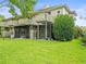 Back exterior view showcasing a screened-in porch and balcony overlooking a well-maintained yard and landscaping at 14134 Trouville Dr, Tampa, FL 33624