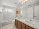Well-lit bathroom with double vanity, tiled floor, and combination bathtub and shower at 14134 Trouville Dr, Tampa, FL 33624