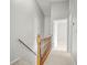 Bright hallway with neutral walls, carpet flooring, a wooden banister, and an open door at 14134 Trouville Dr, Tampa, FL 33624