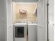 A laundry room with washer and dryer, shelving for storage, and white louvered doors at 14134 Trouville Dr, Tampa, FL 33624