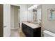 Bathroom featuring a black vanity, a large mirror, and an open door to an adjacent room at 14715 Fishhawk Preserve Dr, Lithia, FL 33547