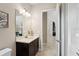 Stylish bathroom with a vanity featuring a dark cabinet and marble countertop, a framed mirror, and a toilet at 14715 Fishhawk Preserve Dr, Lithia, FL 33547
