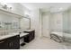 Bathroom featuring modern vanities, tub, and a glass enclosed shower at 14715 Fishhawk Preserve Dr, Lithia, FL 33547