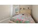 Bright bedroom featuring a colorful patterned bedspread, charming decor, and a window with natural light at 14715 Fishhawk Preserve Dr, Lithia, FL 33547