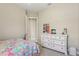 Bright bedroom featuring a large dresser with decor, plush carpet, and open doorway at 14715 Fishhawk Preserve Dr, Lithia, FL 33547