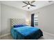 Bedroom with a plush blue bed, tufted headboard, ceiling fan, and a window with a curtain at 14715 Fishhawk Preserve Dr, Lithia, FL 33547