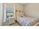 Cozy bedroom with patterned bedspread, bedside table with lamp, and window for natural light at 14715 Fishhawk Preserve Dr, Lithia, FL 33547